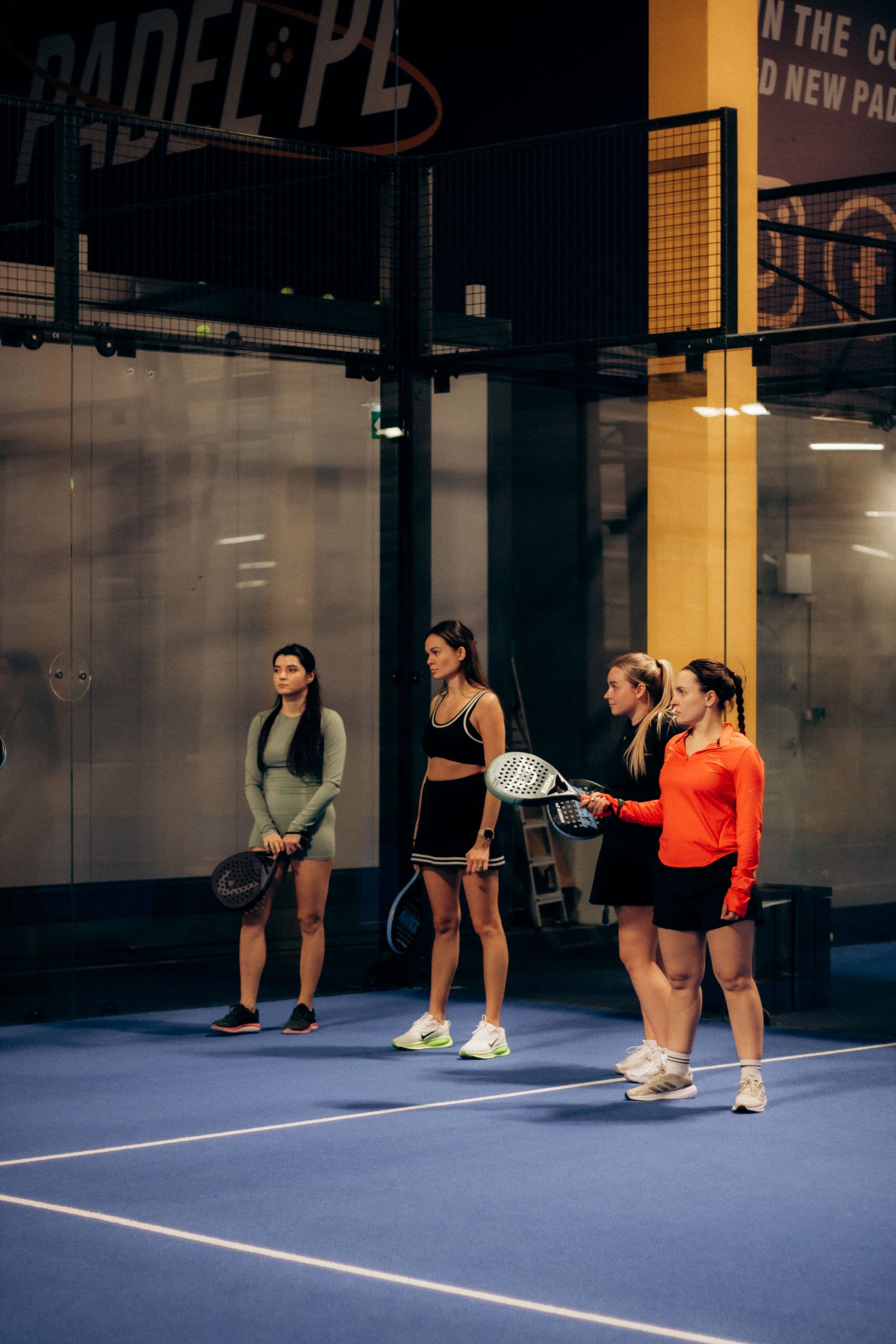 Vier Spielerinnen auf einem blauen Padel-Court